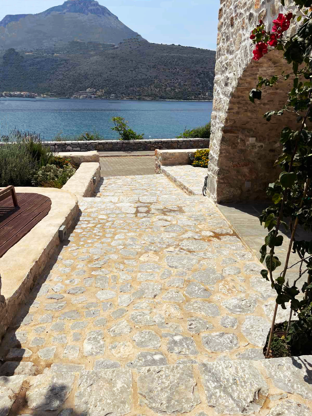 Πλακόστρωτο δρομάκι έξω από τη σουίτα Σίκλος στο Καραβοστάσι με θέα θάλασσα